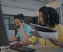 2 associates wearing headsets. They’ve been with the team for 3 years thanks to Pathstream, resulting in retention cost savings for their company.