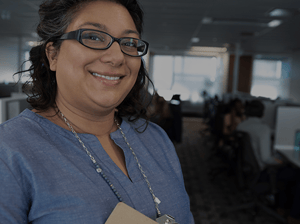 Smiling contact center employee looks into camera to represent how leaders and reps supported by Pathstream programs stick around longer and boost team retention.