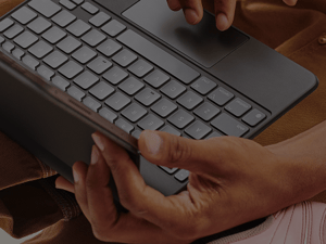 Woman holding a keyboard to represent how university certificate programs for customer contact from Pathstream lead to better performance, like improving FCR by 14%.